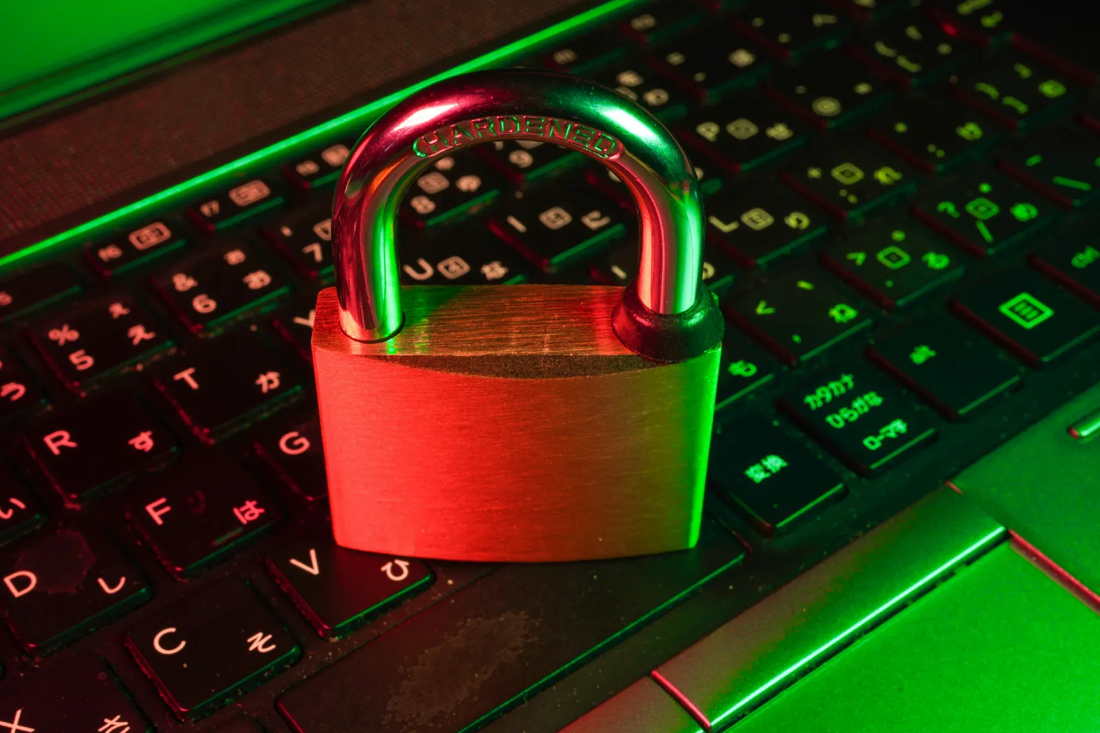 Cadeado sobre o teclado de um notebook, iluminado em vermelho e verde